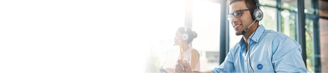 Especialista da ADT com headset atendendo em um escritório iluminado